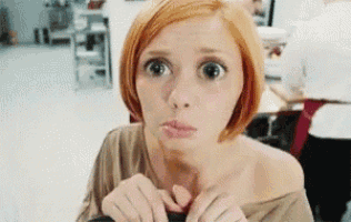 a woman with short red hair is making a funny face