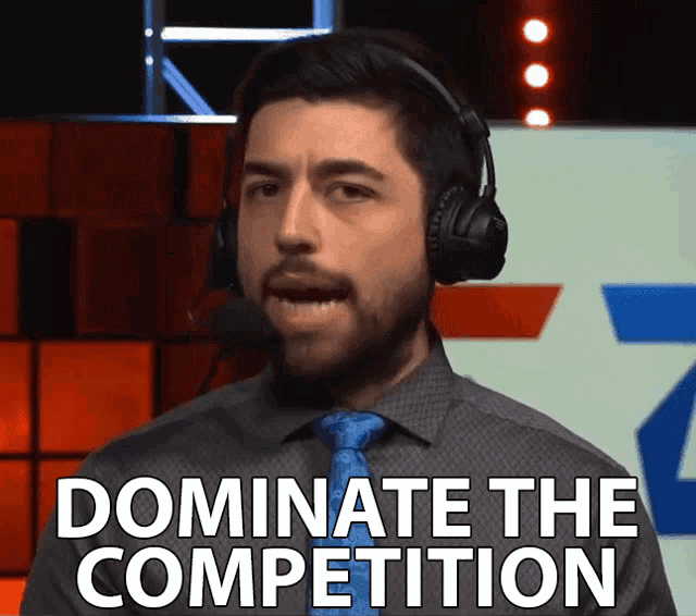 a man wearing headphones says " dominate the competition " in front of a microphone