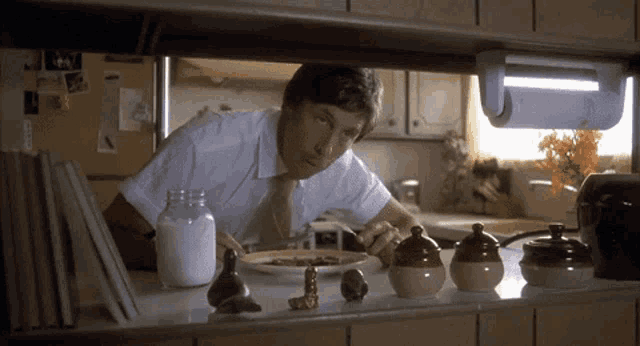 a man in a white shirt and tie is eating breakfast