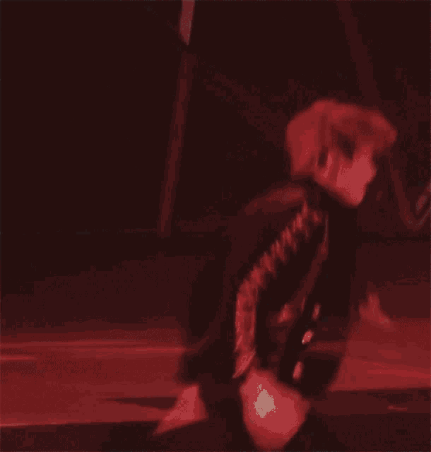 a man in a black suit is dancing in the dark