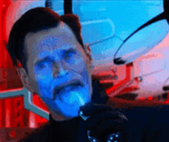 a man with a blue face is holding a microphone