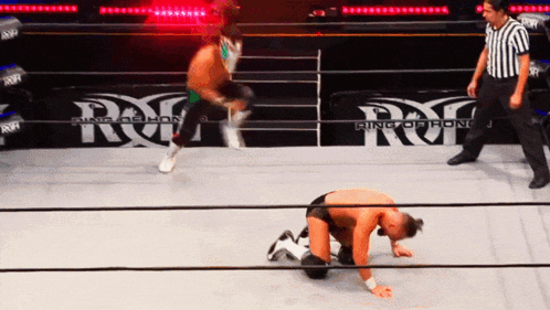 a wrestler is kneeling down in front of a ring that says ring of iron