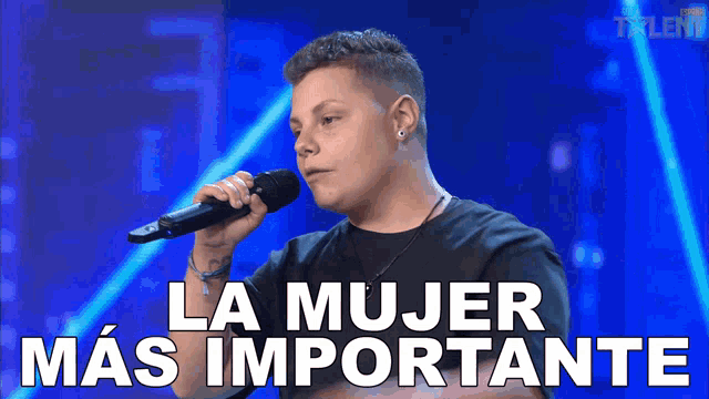 a man singing into a microphone with the words la mujer mas importante written below him