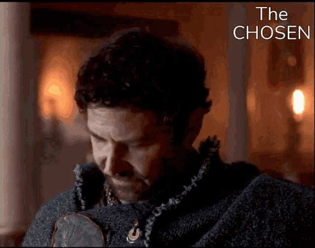 a man in a dark room with the words the chosen behind him