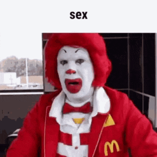 a mcdonald 's clown with a red wig and a mcdonald 's jacket .