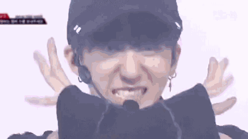 a close up of a person wearing a black hat and earphones .