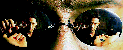 a man is holding a red pill in his hand