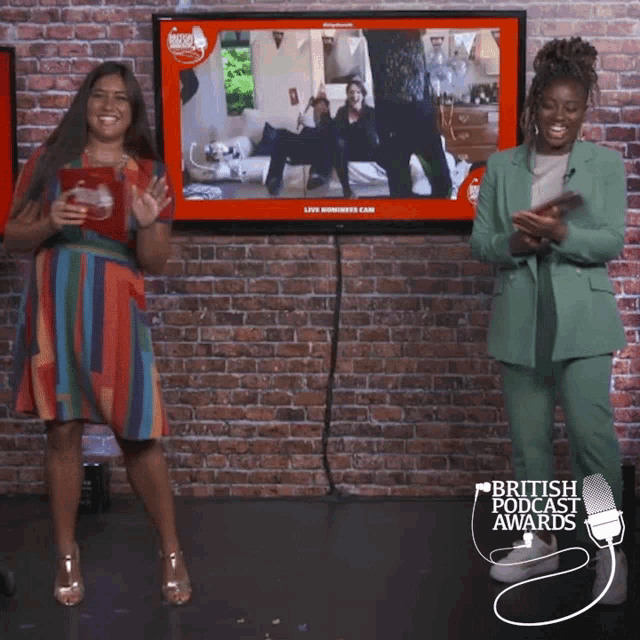 two women are standing in front of a television screen that says british podcast awards