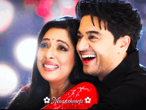 a man and a woman are smiling in front of a banner that says maanhearts