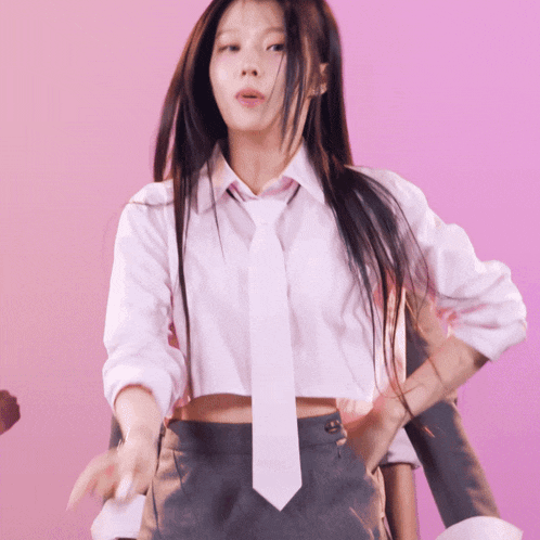 a girl in a white shirt and tie is dancing on a pink background