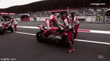 a ducati motorcycle is being worked on by a group of men