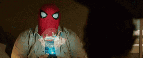 a man in a spider-man mask is looking at a phone .