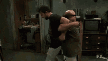 two men are laying on top of each other on the floor .