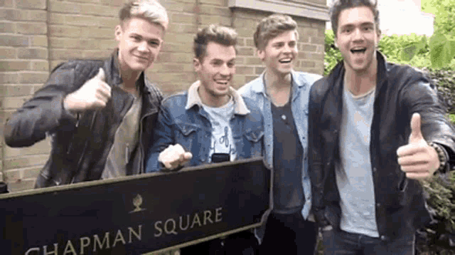 a group of young men are standing in chapman square giving a thumbs up