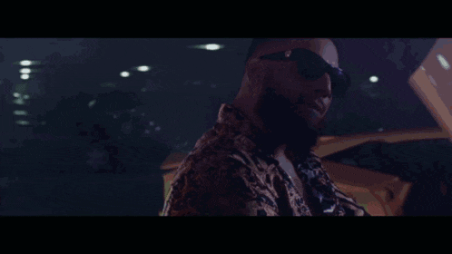 a man with a beard wearing sunglasses is sitting in a car