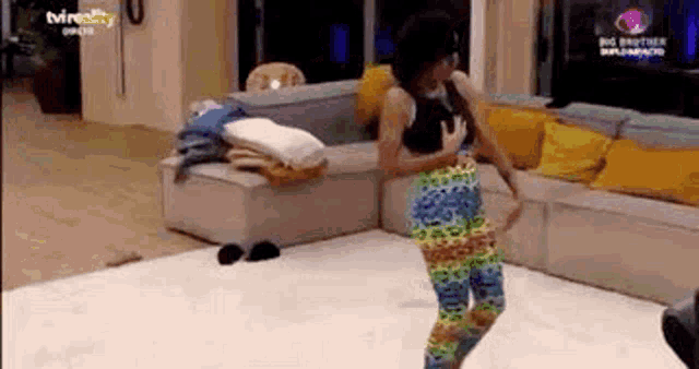a woman is dancing on the floor in a living room .