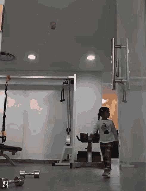 a little girl in a gym with the number 21 visible