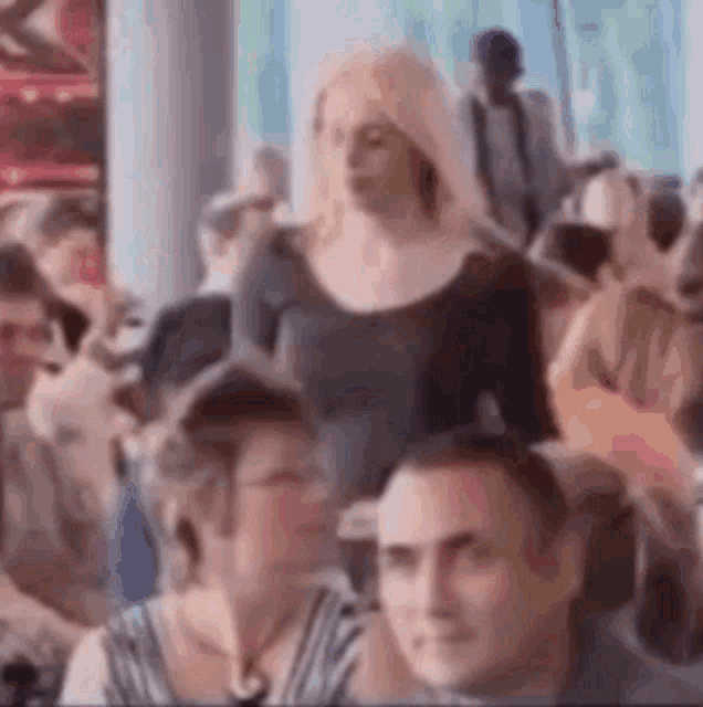 a woman is walking in a crowd of people .