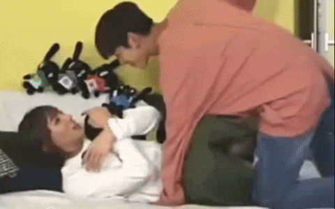 two young men are laying on a bed .