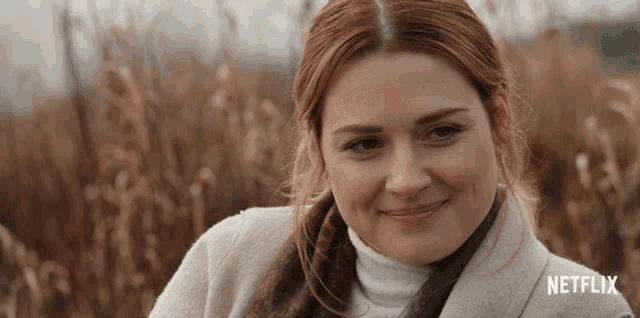a woman in a field with a netflix logo on the bottom