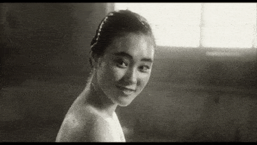a black and white photo of a naked woman in a bathtub .