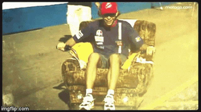 a man wearing a blue shirt with the word elf on it sits on a chair