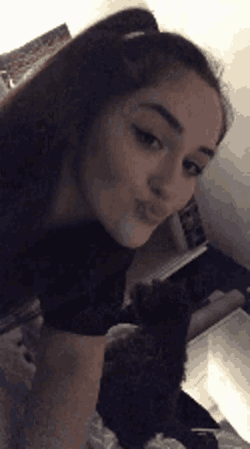 a woman is taking a selfie with a stuffed animal in the background .