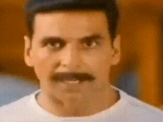 a man with a mustache is looking at the camera .