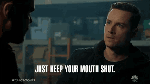 a man says just keep your mouth shut while talking to another man in a dark room