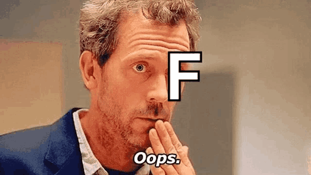 a man in a suit is covering his mouth with his hand and has the letter f on his forehead .
