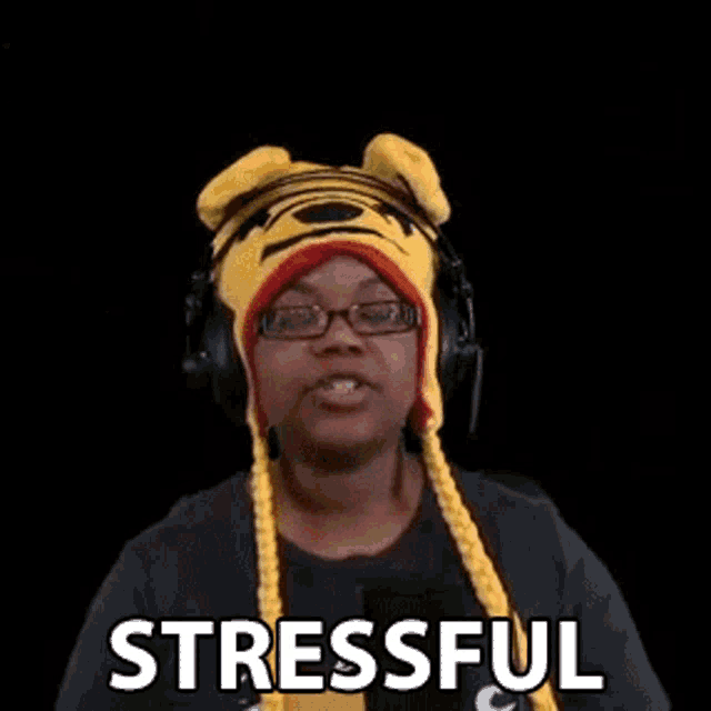 a woman wearing a winnie the pooh hat and headphones is stressed .