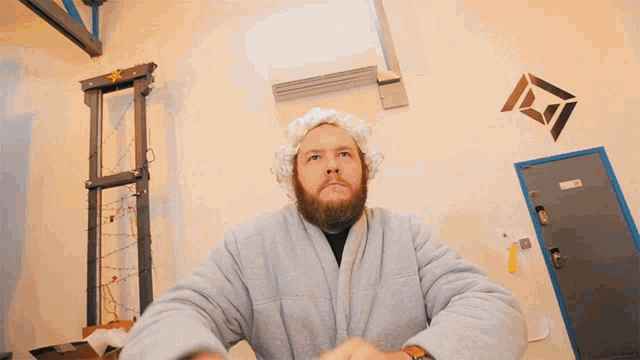 a man with a beard wearing a bathrobe is looking up