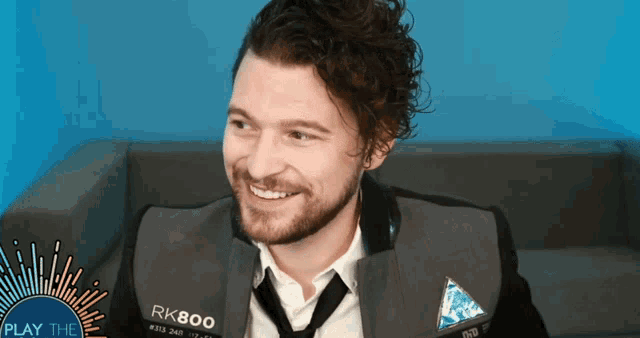 a man wearing a suit and tie with rk800 on the front