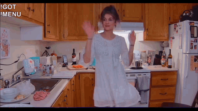 a woman in a white dress is dancing in a kitchen with the words i got menu below her