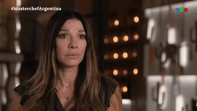 a woman in a dark room with the words masterchef argentina on the bottom