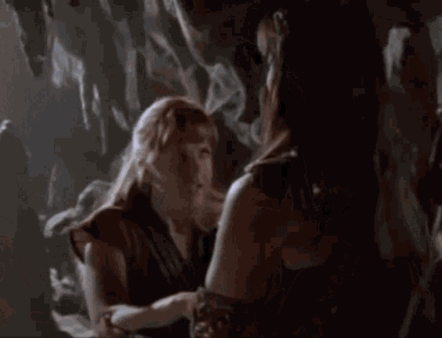 a couple of women are standing next to each other in a cave