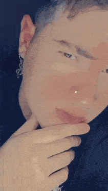 a man wearing a nose ring and earrings with the name vook on the bottom