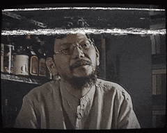 a man with glasses and a beard is looking at something