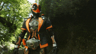 a man in an orange and black suit is holding a sword