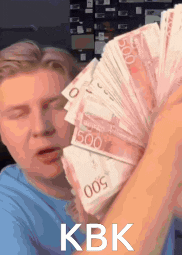 a man is holding a stack of 500 bills in his hand