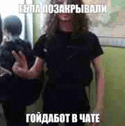 a man with long hair and a beard is standing in front of a mirror and giving a peace sign .