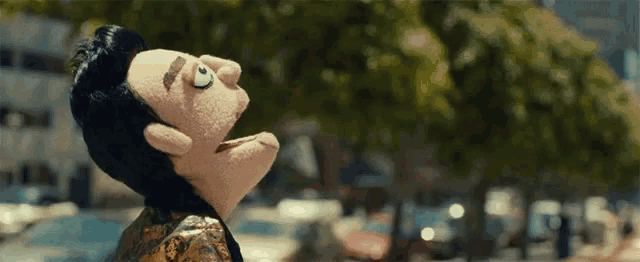 a puppet with a big nose is looking up in the sky