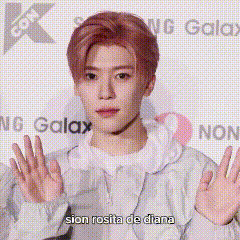 a man with pink hair is standing in front of a sign that says samsung galaxy .