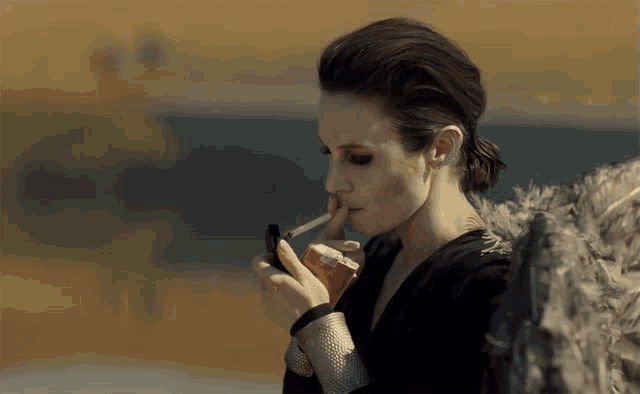 a woman is smoking a cigarette with a lighter in her hand