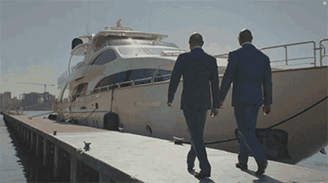 two men in suits are walking towards a boat that says ' shannon ' on it