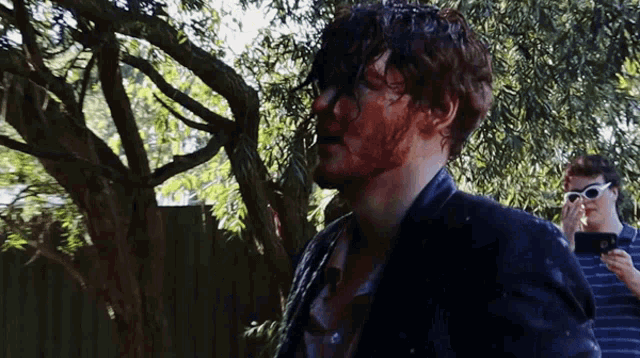 a man with blood on his face stands next to another man