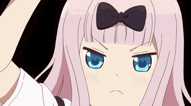 a girl with a bow on her head makes a funny face