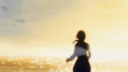 a girl with her arms outstretched stands on the beach