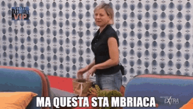 a woman is standing in front of a wall that says ma questa sta mbriaca