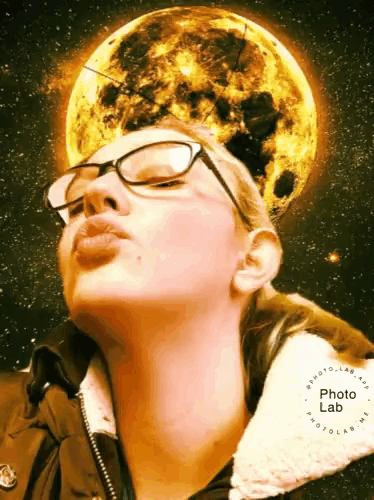 a woman wearing glasses is blowing a kiss in front of a full moon with a photo lab logo around her neck